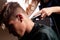 Master hairdresser cuts guy making fashionable stylish haircut