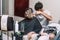 Master hairdresser cuts hair of blond woman. Baby in pram while mother having haircut in salon