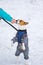 Master hand feeding basenji dog wearing winter coat and standing on a hind legs on a snow