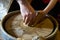 The master helps the child to make a pot of clay on pottery wheel,