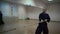 Master kendo exercises with a wooden sword in the sports hall with mirrors