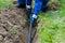 Master lays a pipe in the ground for a summer water supply in a country house