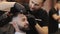 The master makes the contour of the haircut. Men`s haircut in a barbershop. Professional barber shaves customer with