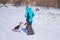 Master playing with black mixed breed and basenji dog on countryside on at winter season