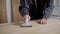 Master is polishing wooden surface during repair inside an apartment, using hand tools, close-up of hands