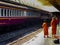 Master and pupil Buddhist monks talking and waiting for the train