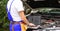 Master repairman holding laptop near open hood of car closeup.