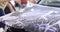 Master repairman wrapping vinyl polyurethane film on hood of car in workshop 4k movie