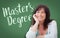 Master`s Degree Written On Green Chalkboard Behind Smiling Woman