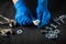 The master tightens the nut with a wrench on the bolt closeup. Working environment on a table in a workshop with tools