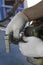 The master in working gloves repairs the engine of the old gas trimmer and unscrews the carburetor and air filter cover with the