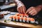 Masterful sushi craftsmanship: chef and fresh salmon