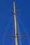 Masthead wooden mast against blue sky