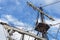 Masts and rigging of old pirate ship on background of cloudy blue sky