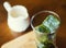 Matcha green tea ice cubes with fresh milk on wooden table