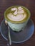 Matcha green tea latte with beauitiful latte art and served in a glass