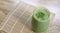 Matcha Green Tea Smoothie in glass on bamboo mat on table