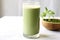 matcha latte in a tall glass, mint sprig on top