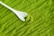 Matcha powder background with small white spoon. Green tea texture close up