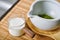 Matcha tea powder in white clay tea bowl with milk, Matcha latte ingredients, Green tea making set