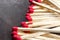 Matches with red sulfur on a dark wooden background. Macro