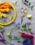 Materials for embroidery: scissors, canvas, threads and embroidery frame. Small colorful flowers around