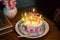 maternal grandmother birthday cake decorated with lighted candles at coffee table