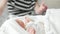 Maternity hospital - employee of the hospital is swaddling a newborn baby