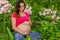Maternity Yoga woman in flowers holding her belly