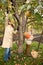 Mather and son gather apples in autumnal garden