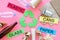 Matherials suitable for recycle near green recycle eco symbol. Words paper, glass, plastic, cans on pink background top
