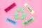 Matherials suitable for recycle near green recycle eco symbol. Words paper, glass, plastic, cans on pink background top