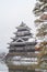 Matsumoto Castle with tree branches and snow in winter season, Nagano, Japan. Architecture landscape background in travel trip
