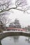 Matsumoto Castle with tree branches and snow in winter season, Nagano, Japan. Architecture landscape background in travel trip