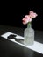 Matte glass vase with delicate pink roses on dark background