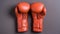 Matte Photo: Pair Of Orange Boxing Gloves On Grey Background