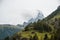 Matterhorn in clouds and traditional wooden houses and farm buildings on the slope. Zermatt, Swiss Alps. Adventure in