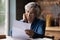 Mature 60s woman read paper postal correspondence at home