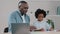 Mature african american grandfather helps granddaughter with homework little girl surprised draws painting grandpa