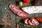 Mature air dried sausage, Fuet fresh and sliced on wooden board closeup. Spanish traditional sausage sliced on a wooden board.