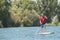 Mature attractive rider contemplating nature sitting on paddle board