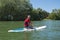 Mature attractive rider contemplating nature sitting on paddle board