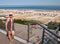 Mature baby boomer woman posing on balcony overlooking beach and