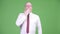 Mature bald businessman covering mouth while looking guilty