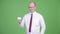 Mature bald businessman turning coffee cup upside down