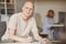 Mature Bald Woman Signing Papers at Doctors Office