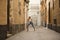 Mature, beautiful, blonde woman in white top and jeans, posing in funny attitude on a lonely city street. Concept beauty, fashion