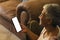 A mature biracial senior woman checks her smartphone at home, with copy space