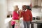 Mature black couple celebrating on Christmas day drinking a toast with arms entwined, selective focus