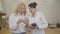 Mature blond Caucasian woman teaching her friend using smart phone. Portrait of two senior ladies in white shirts